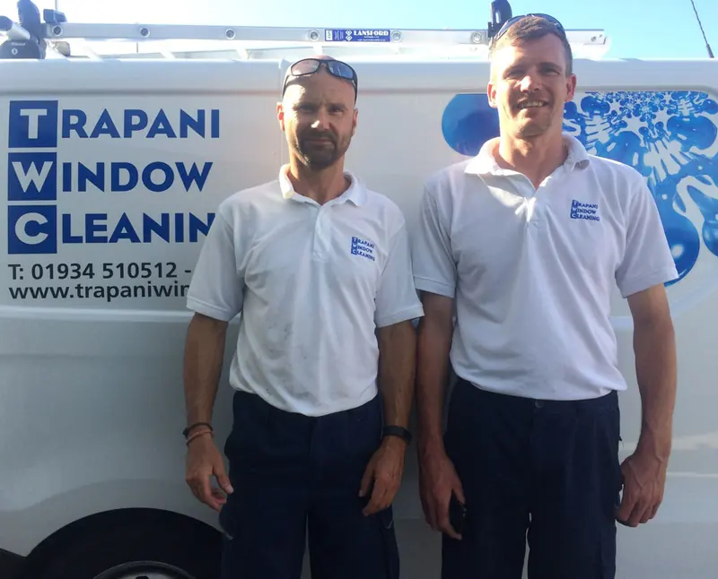 Two Trapani Window Cleaning team members in front of a company van